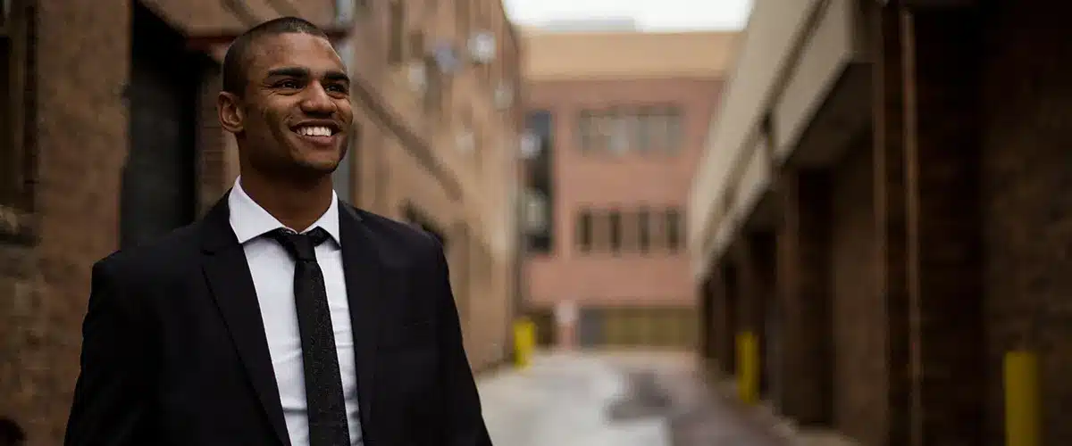 A smiling businessman in a suit on a city street