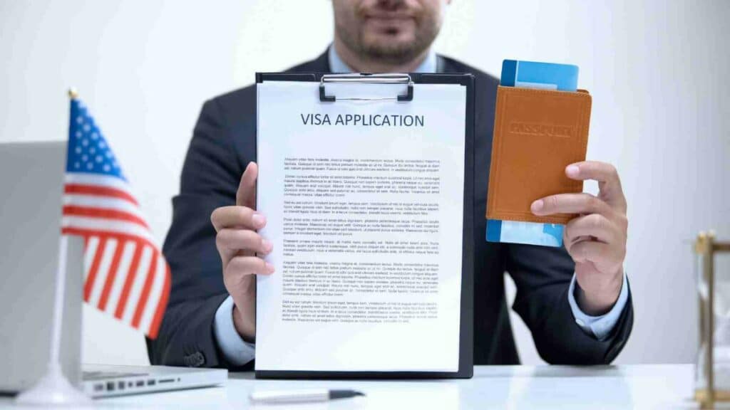 An immigration lawyer holding a visa application form, brown passport, ticket with american flag