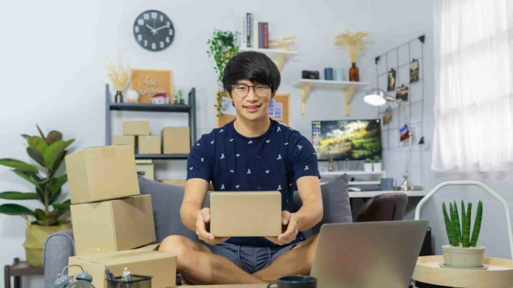 A Japanese man holding a box and selling its E2 Visa bussiness