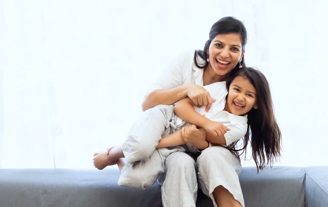 Happy mother and daughter laughing together in the USA under E2 VISA dependent