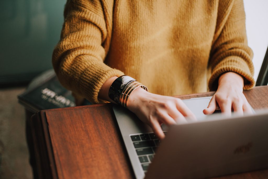 A picture of someone typing in a laptop